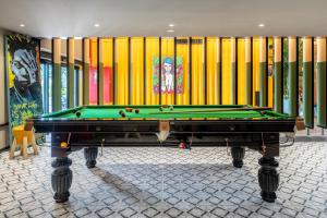 a pool table in a room with a yellow wall at The Spot Hostel in Tel Aviv