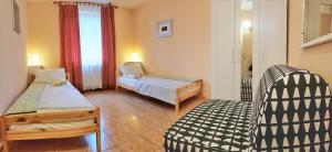 a bedroom with two beds and a chair in it at Apartments Lori in Poreč