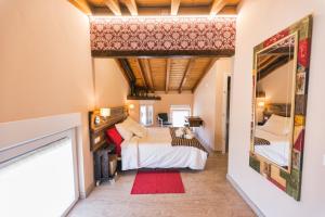 a bedroom with a bed and a mirror at Las Postas del Perionda in Calzada de los Molinos