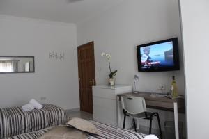 a bedroom with a desk and a bed and a tv at Cosy Home in Mellieħa