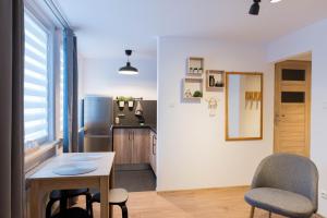 a kitchen with a table and chairs in a room at Apartament Szyszka in Ustrzyki Dolne