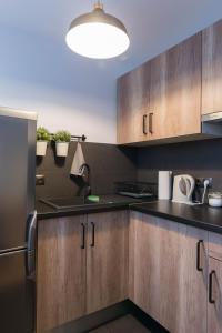 a kitchen with wooden cabinets and a refrigerator at Apartament Szyszka in Ustrzyki Dolne