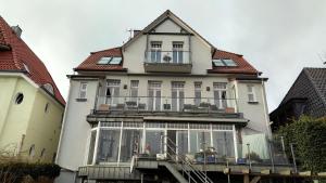 a large white house with a balcony on top of it at Hotel Ambiente in Brake