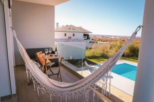 a hammock on a balcony with a view of a pool at Marlin House III in Peniche