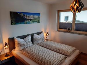a bedroom with a bed with pillows and a window at Apart Alexandra in Strass im Zillertal