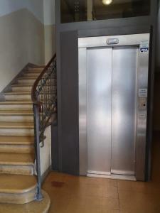 a metal elevator in a building with a staircase at Liluna in Bologna
