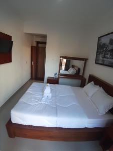 een slaapkamer met een groot wit bed in een kamer bij D&D homestay in Pesanggaran