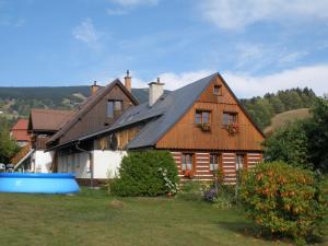 a large wooden house with a gambrel roof at Chalupa 409 in Rokytnice nad Jizerou