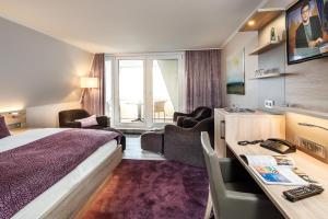 クックスハーフェンにあるWattenkiekerのベッドとデスクが備わるホテルルームです。