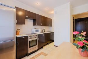 a kitchen with brown cabinets and a microwave at ОК! Красноармейская, 151 in Tomsk