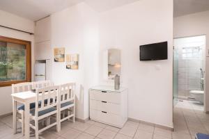 a white bathroom with a table and a sink and a toilet at Villa Victoria by La Scala Beach in Limenas