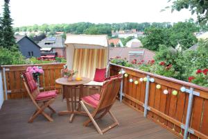 a deck with a table and chairs on a balcony at Haus Hanseatic Ferienwohnungen in Bad Harzburg