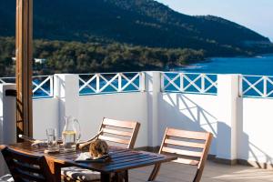 a cat sitting on top of a table on a balcony at Villa Victoria by La Scala Beach in Limenas