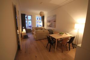 a living room with a table and a couch at Royal Residence in Lübeck +28 photos