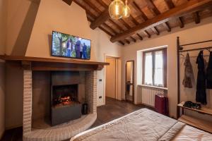 sala de estar con chimenea y TV encima. en Borgo Degli Angeli Resort e Spa, en San Vitale