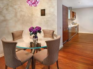 una mesa de comedor con sillas y un jarrón de flores púrpuras en Galateia Residence, en Estambul