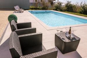 a table and chairs next to a swimming pool at Marlin House III in Peniche