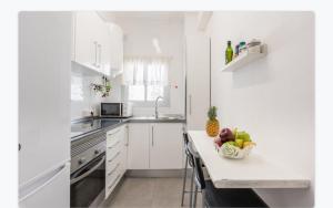 トレモリノスにあるCasaFloriの白いキッチン(カウンターにフルーツを入れた器付)