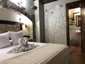 a bedroom with a bed with white sheets and butterflies on the wall at Posada La Cuadrona in La Hermida