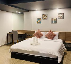 1 dormitorio con 1 cama grande y escritorio en Toptel Thaphra - ท็อปเทล ท่าพระ en Bangkok