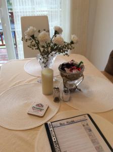 una mesa con un jarrón de flores y una vela en Haus Willer, en Erding