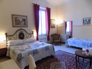a hotel room with two beds and a table at Soggiorno Pitti in Florence