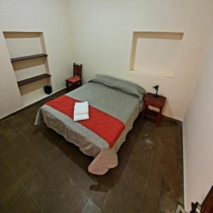 ein Schlafzimmer mit einem Bett mit einer roten Decke in der Unterkunft Mirador de Salta House in Salta
