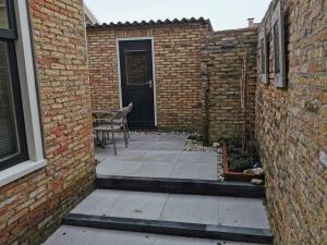 a patio with a door and a table and chairs at Heiligeweg 48 in Harlingen
