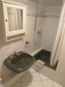 y baño con lavabo verde y ducha. en Ferienwohnung Blankenstein, en Hattingen