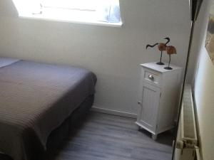 Un dormitorio con una cama y una mesita de noche con dos pájaros. en Appartement in der Waldsiedlung, en Leverkusen