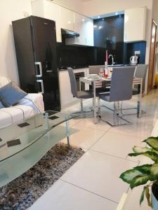 a living room with a glass table and a couch at Seabreeze Apartment in St Paul's Bay