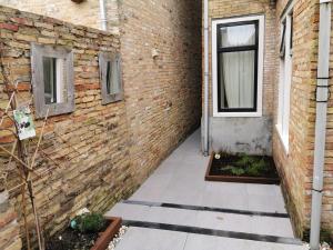a brick wall with a door and a window at Heiligeweg 48 in Harlingen