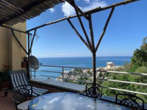 balcone con tavolo, sedie e vista sull'oceano di Flower Power Apartment (Positano) a Positano