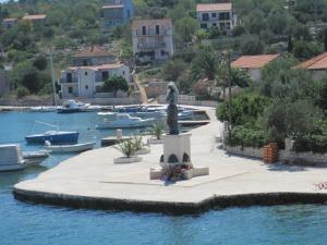 una estatua en medio de un cuerpo de agua con barcos en Spansa, en Veliki Drvenik