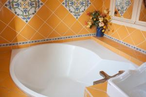 een badkamer met een wit bad en een vaas met bloemen bij Maison de Pêcheur in Toulon