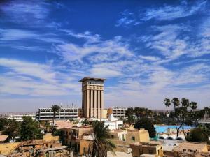 a building with a clock tower in front of a city at King Nubian guest house in Aswan