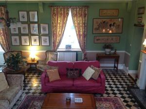 sala de estar con sofá rosa y ventana en La Grange Terrou en Saint-Germain-de-Confolens