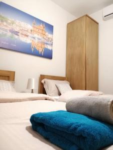 a bedroom with two beds and a painting on the wall at Seabreeze Apartment in St Paul's Bay