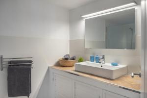 a white bathroom with a sink and a mirror at Casa Amanecer in Tías +15 photos