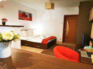 1 dormitorio con 1 cama y escritorio con silla roja en Dristor - Studio D by MRG Apartments en Bucarest