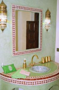 bagno con lavandino e specchio di Riad El Walida a Marrakech