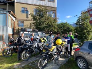 un grupo de personas de pie junto a sus motocicletas en Hosteria Sloggett, en Ushuaia