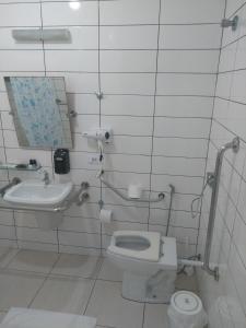 a bathroom with a toilet and a sink at Hotel Rota do Sol in Guaratuba