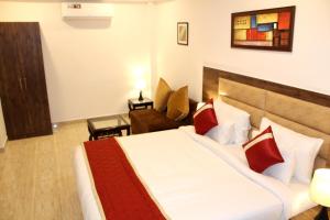 een hotelkamer met een groot bed en een bank bij Red Crown Hotel in New Delhi