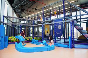 two girls playing in a playground with a slide at Yas Island Rotana Abu Dhabi in Abu Dhabi