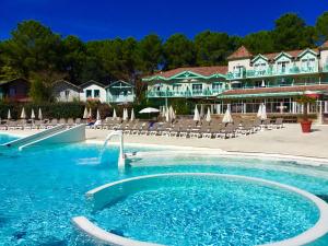 una piscina con scivolo di fronte a un resort di Lumineux, vue piscine, face au Golf, Lacanau Ocean a Lacanau