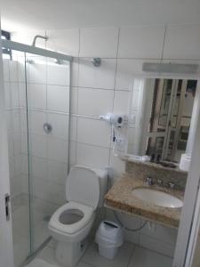 a bathroom with a toilet and a sink and a shower at Rota do Sol Praia Hotel in Guaratuba
