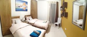 a hotel room with two beds and a mirror at Seabreeze Apartment in St Paul's Bay