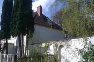 een wit huis met een hek ervoor bij Idyllische Penthouse-Wohnung in super Lage in München