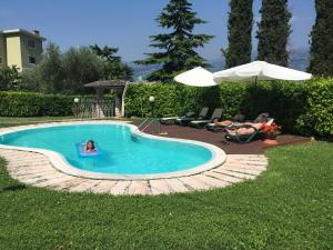 a pool with a child in a toy in the water at Apartments Panoramica in Malcesine